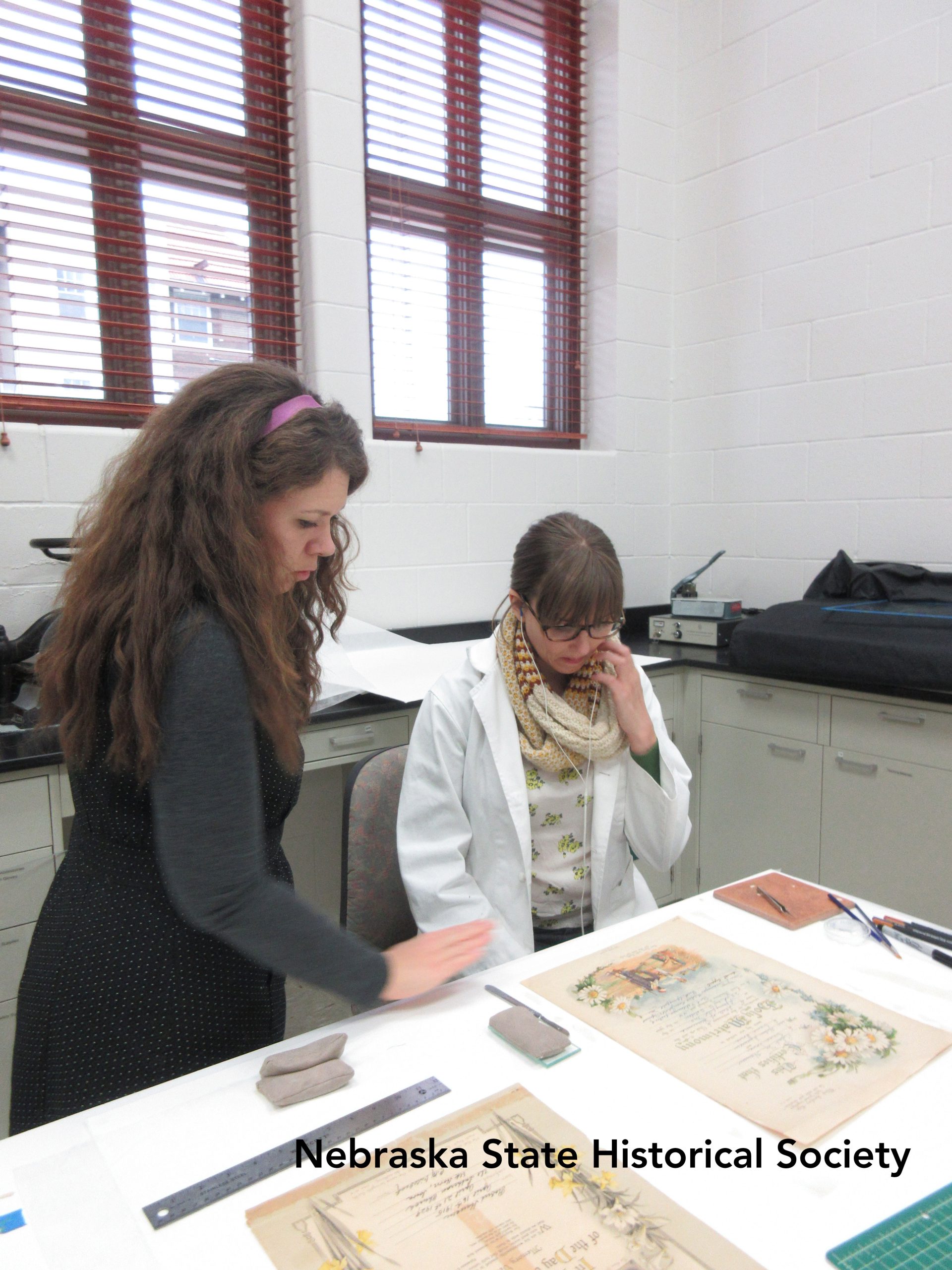Paper conservator Hilary LeFevere and conservation technician Megan Griffiths work on paper objects at the Ford Conservation center.