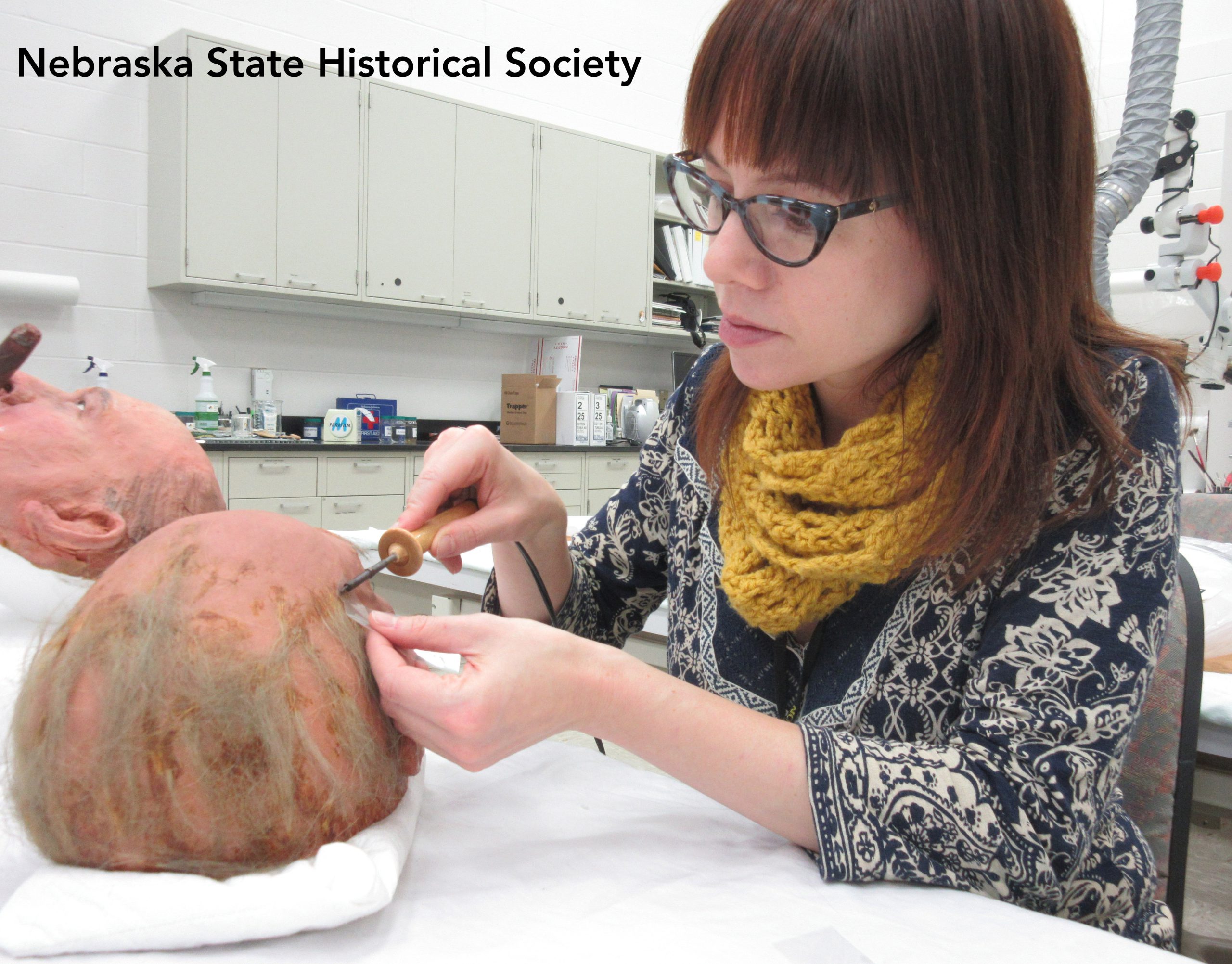 Assistant Objects Conservator Rebecca Cashman works on one of the Doane Powell masks