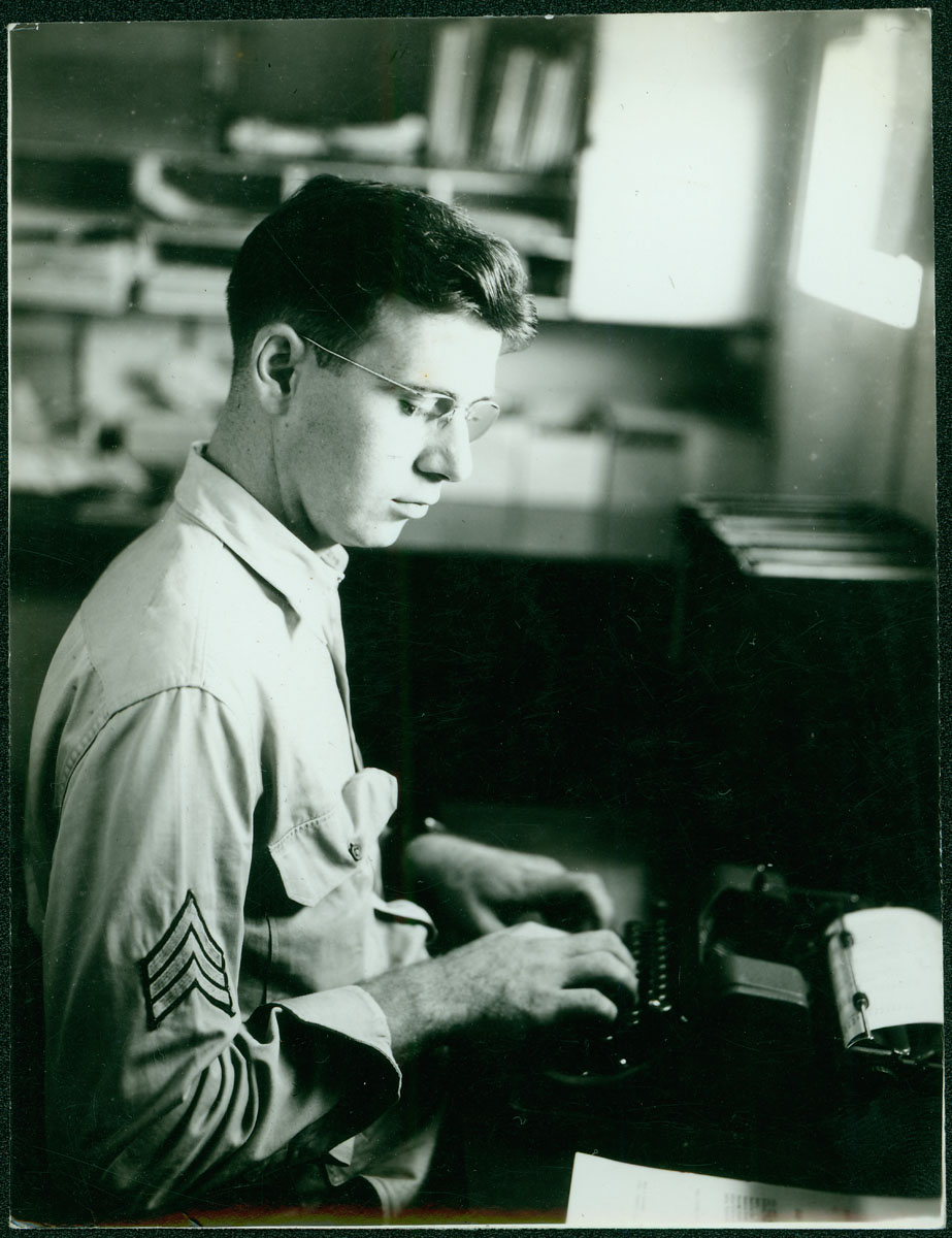 Robert Merchant seated at typewriter [RG5841.PH1-13]