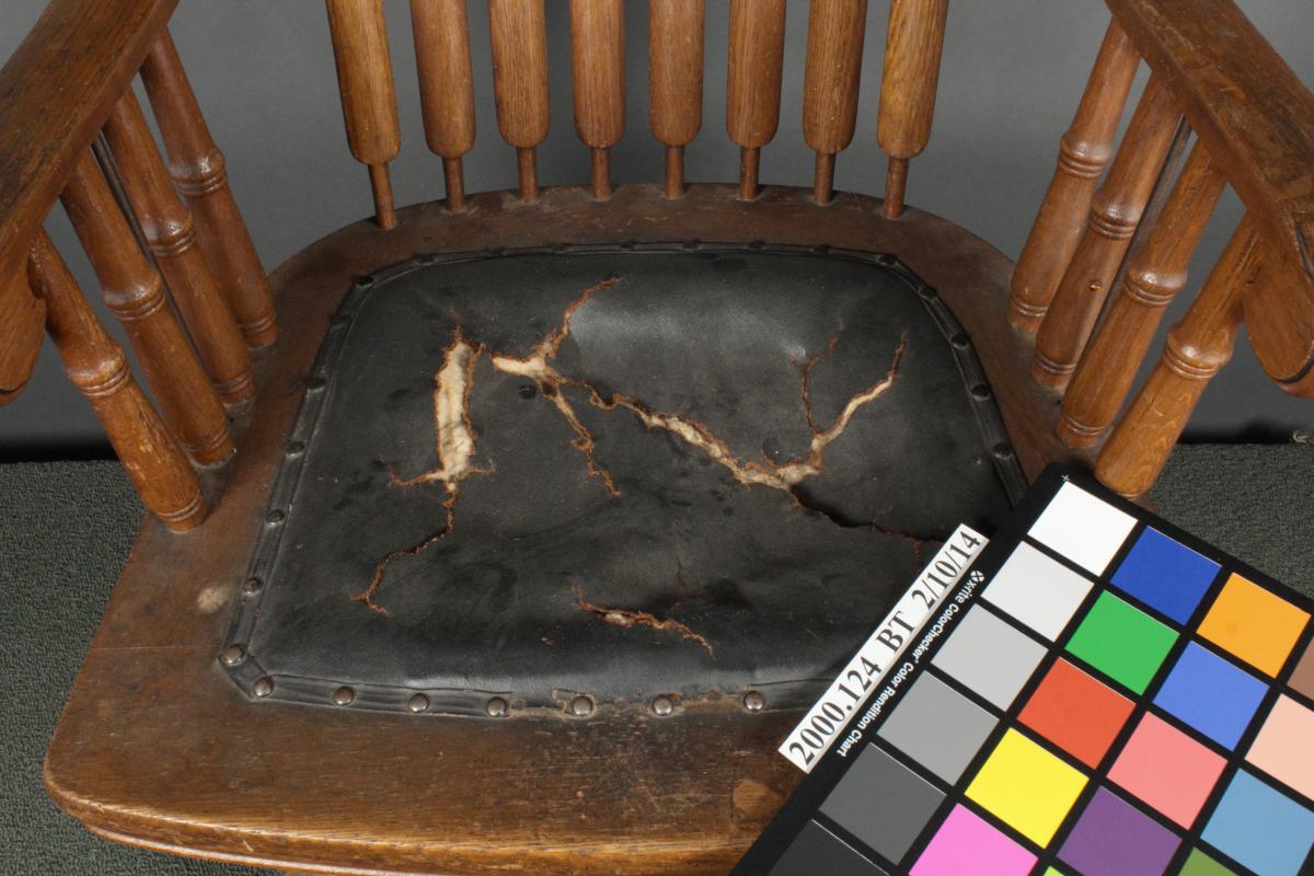 photo of damage to chair's seat cushion, cracked leather