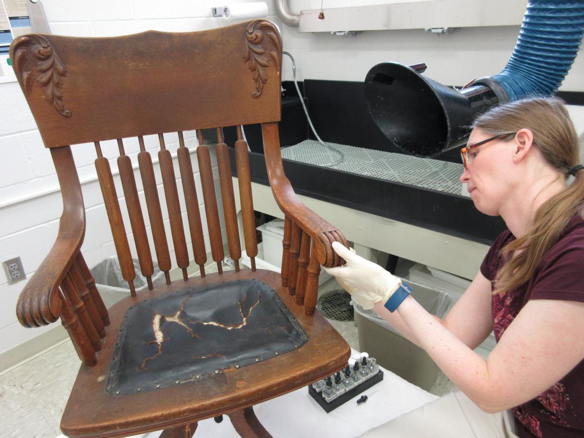 technician cleans the surface of the wooden chair