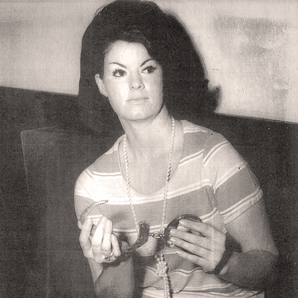press photo of Nancy Bradshaw holding handcuffs, 1970