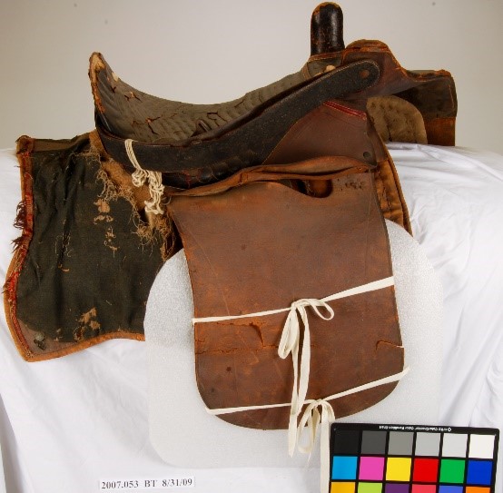 Side saddle before treatment, damage to saddle blanket and leather parts