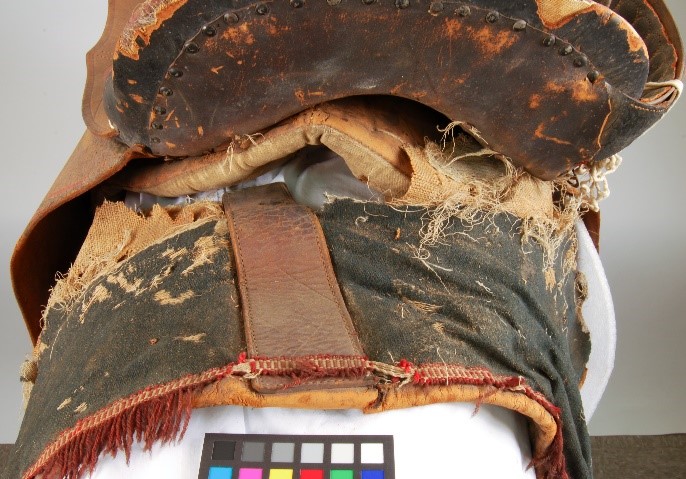View behind the saddle of damage to saddle blanket, frayed textile