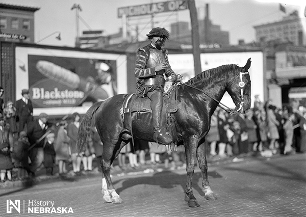 man in Spanish armor on horseback in city street