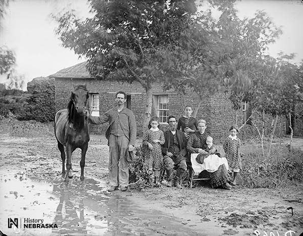 Same as top photo - family in muddy yard in front of soddie