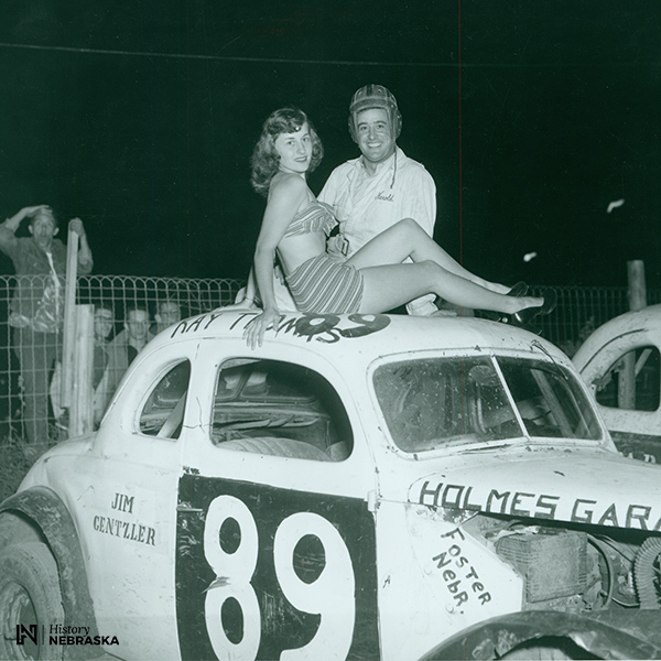 1950s photo of man and woman atop race car