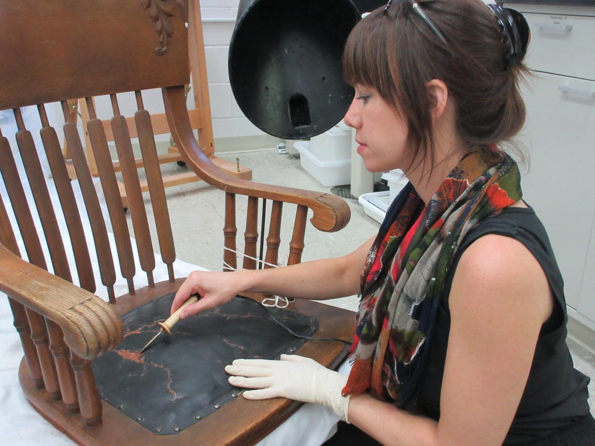 conservator fills losses in leather seat