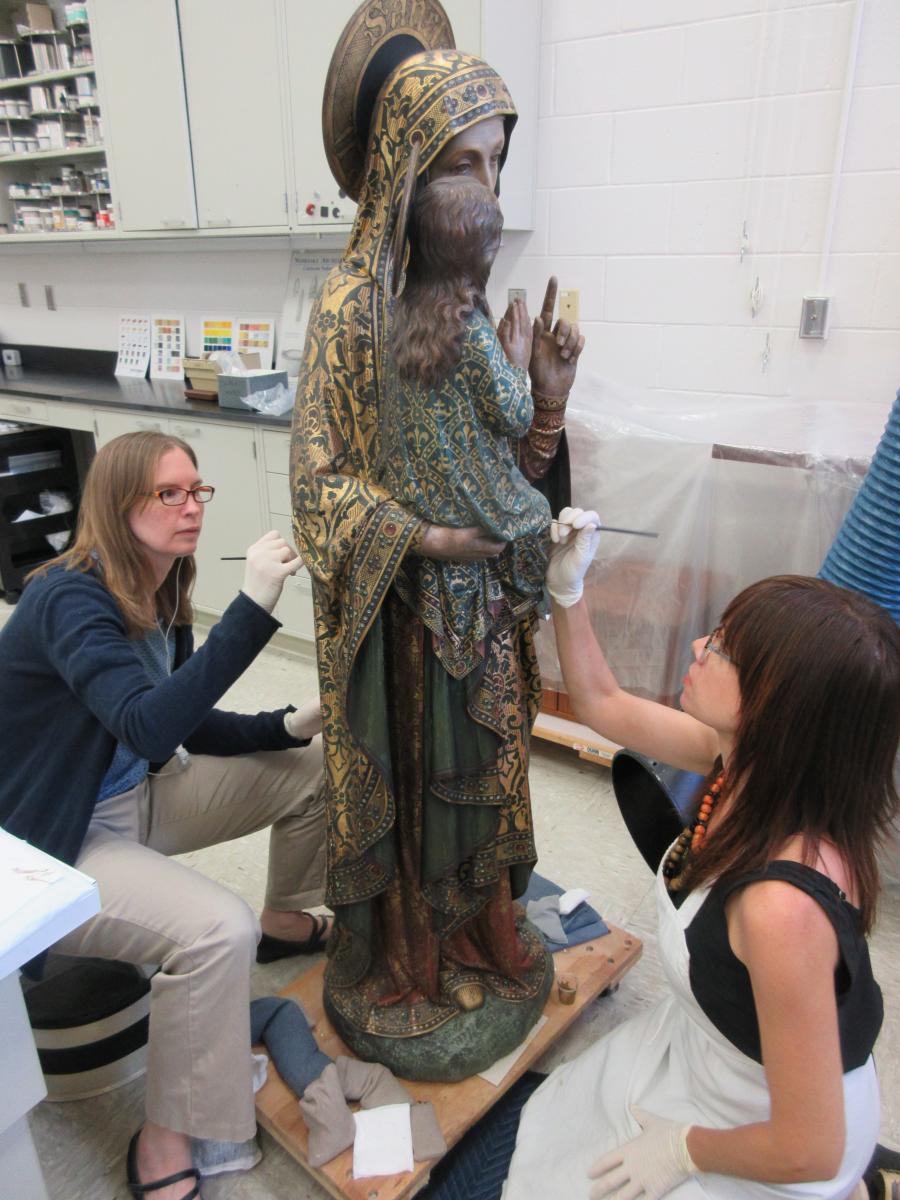 Conservation Technician Vonnda Shaw (left) and Objects Conservator Rebecca Cashman (right) inpaint losses on the sculpture.
