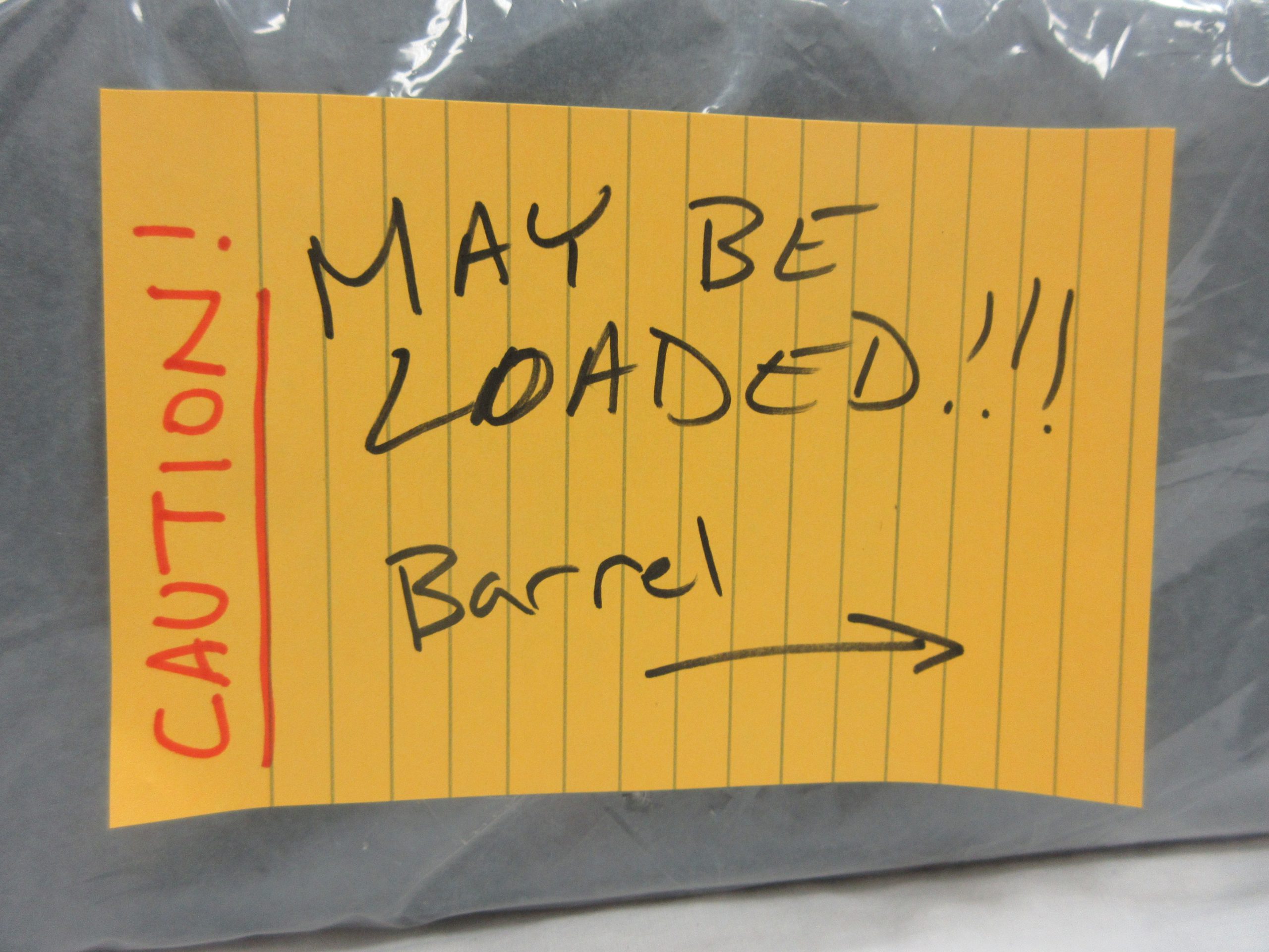 "Caution, May Be Loaded" label on box containing firearm.
