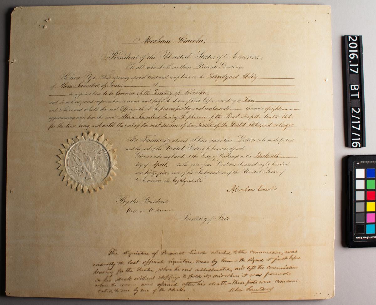 raking light photo of certificate, showing surface damage and distortions, before treatment