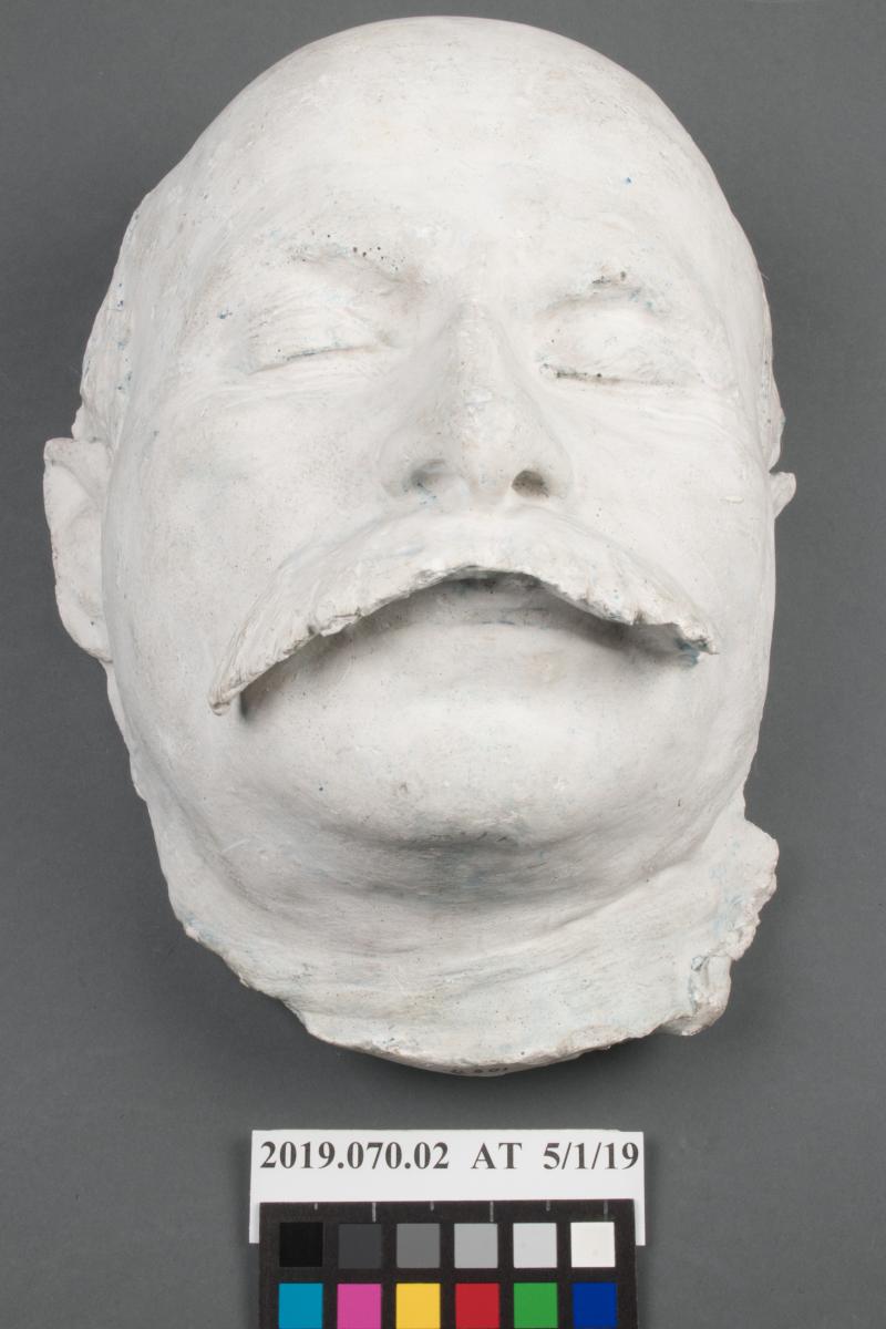 after treatment photo of death mask of man with large mustache, white in color
