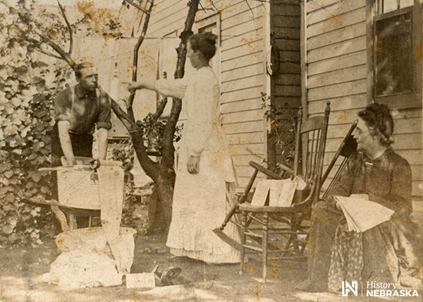 A 1902 photo shows man washing clothes, and a woman pointing at him as if giving orders.