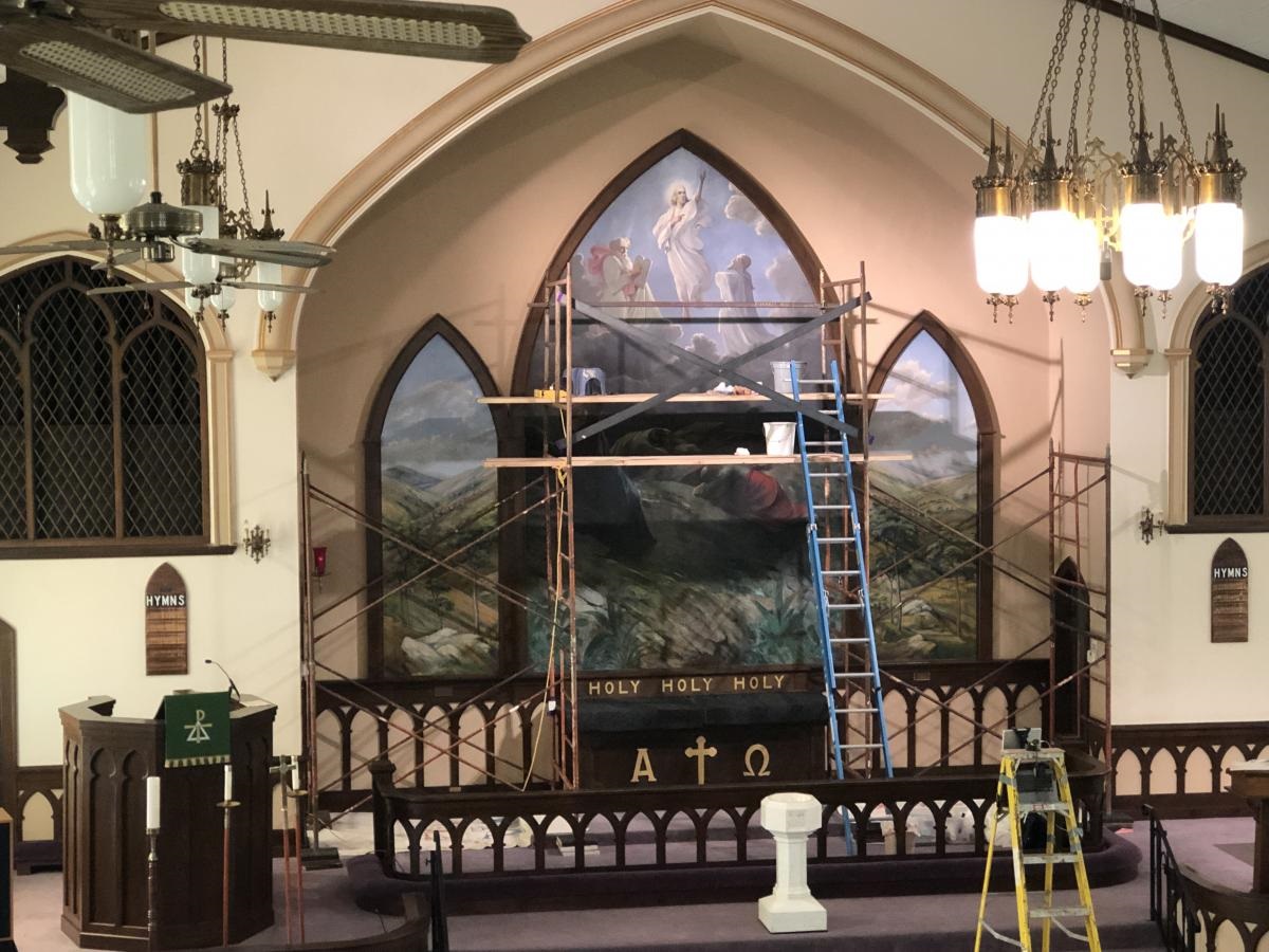 mural of Transfiguration behind alter. Scaffolding set up in front of mural.