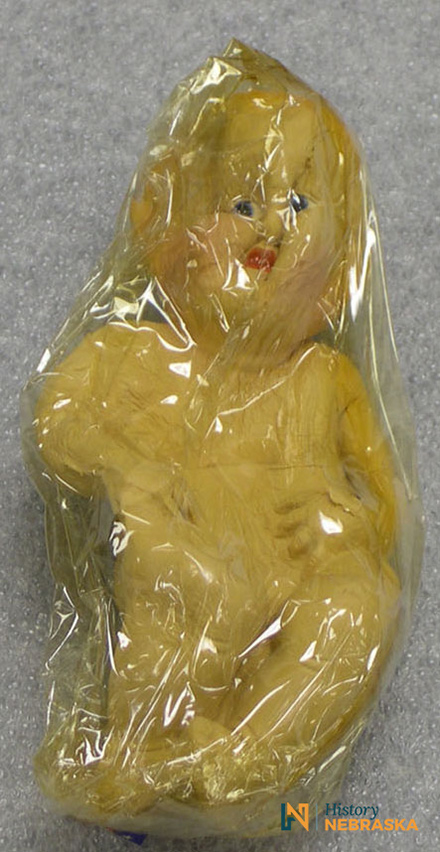 Distorted rubber baby doll wrapped in plastic