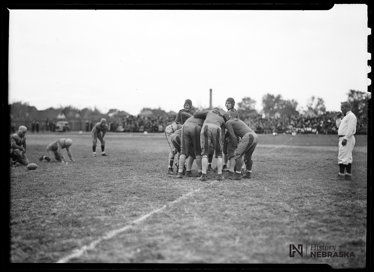 The University of Omaha football team in the huddle during a game. 1935.