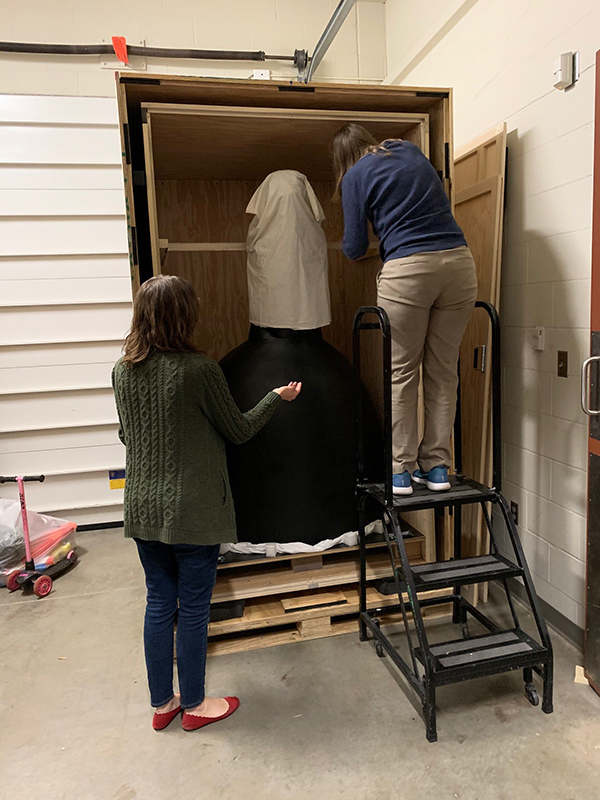 Ford Center staff unpack the Sibande sculpture from its crate.