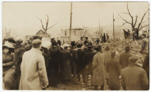 A picture postcard of a crowd of people amid the ruins of houses in Omaha, NE after the 1913 tornado. 