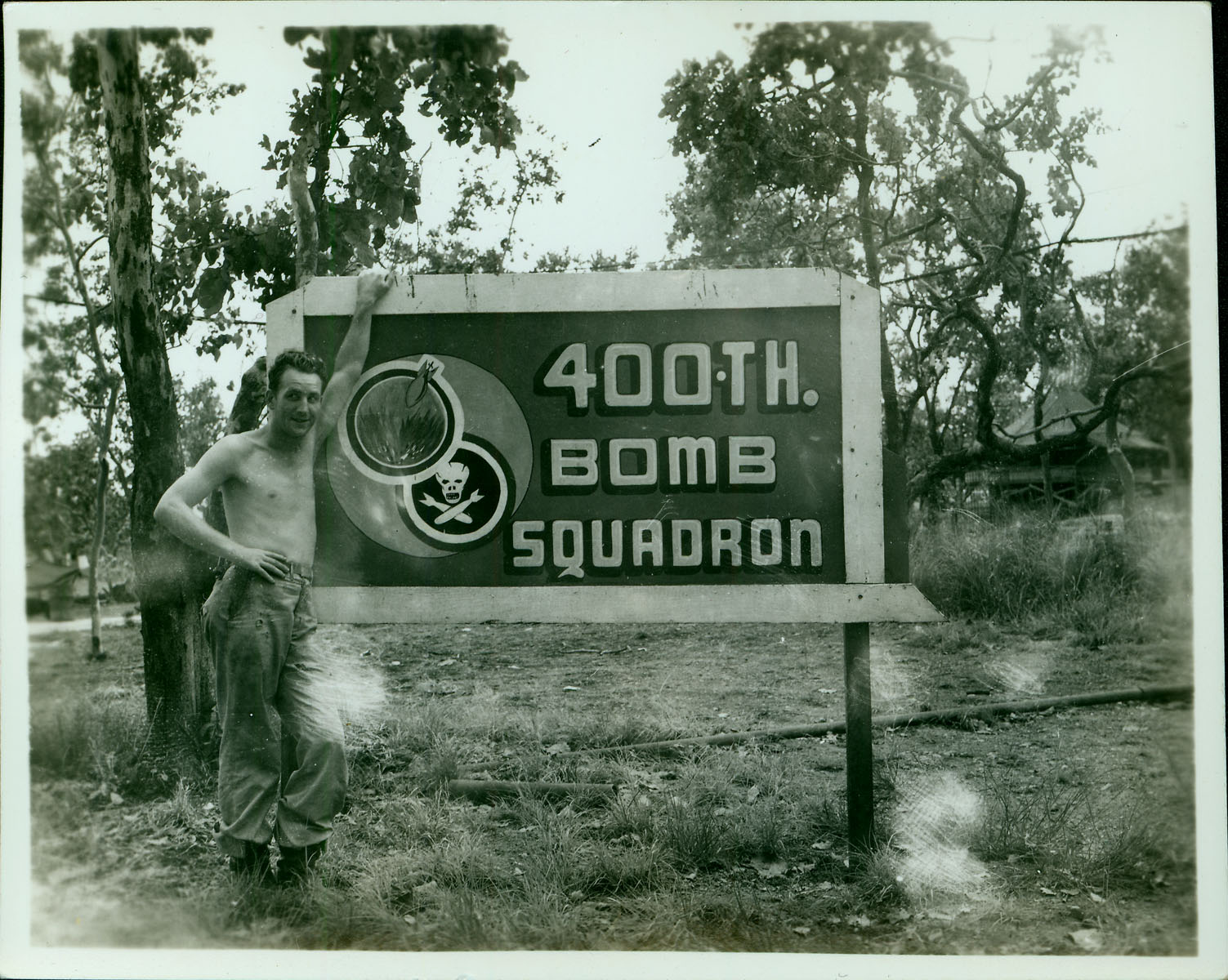 An Army officer poses in front of a base sign for the “400th Bomb Squadron”.