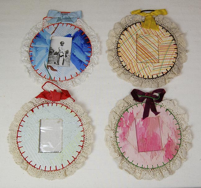 Picture frames made of two round pieces of cardboard with lace. (NSHS 7144-11, 12, 13, 14)