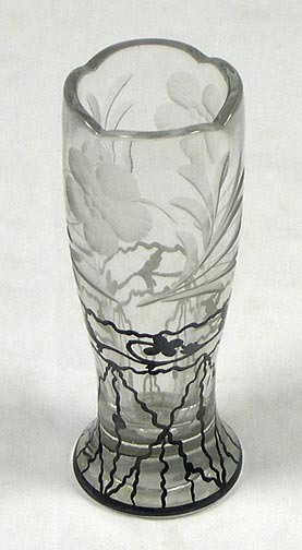 Small glass flower vase engraved with two five-petal flowers and leaves. Bottom half has painted black floral and geometric lattice design. Top rim is faceted. Vase is 4.75" (12 cm) tall and 1.6" (4 cm) in diameter at the base. (NSHS 7144-146)