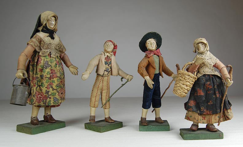 Left to right:   Female figurine in a folk costume holding a bucket. (NSHS 7144-171)  Male figurine in a folk costume holding a crook. (NSHS 7144-170)   Male figurine in a folk costume holding a crook. (NSHS 7144-169)   Female figurine in folk costume carrying a woven straw basket. (NSHS 7144-172)