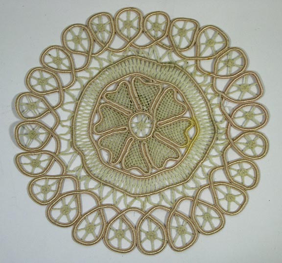 Doily (NSHS 7144-211) Doily with a flower in the center that is surrounded by a macramé border. 