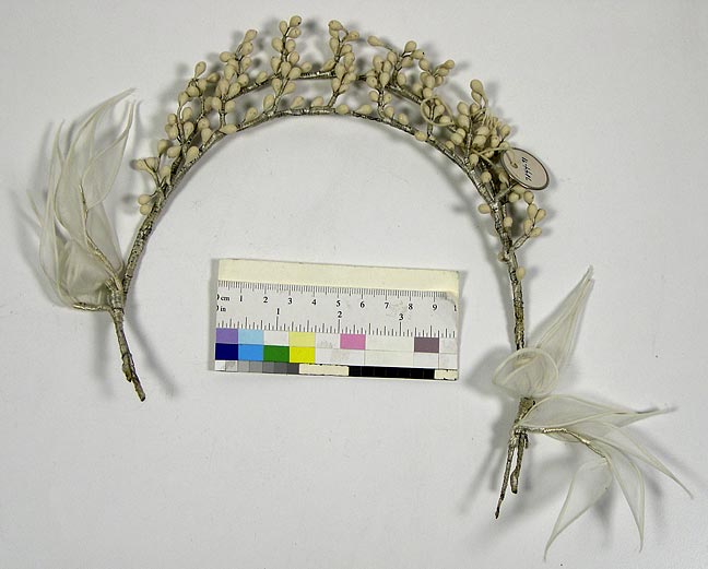 Tiara (NSHS 7144-91 [dupl]) Tiara made of twisted wire wrapped with white fiber cord. The top is decorated with small berries and multiple gossamer leaves or wings attached to the ear area. 