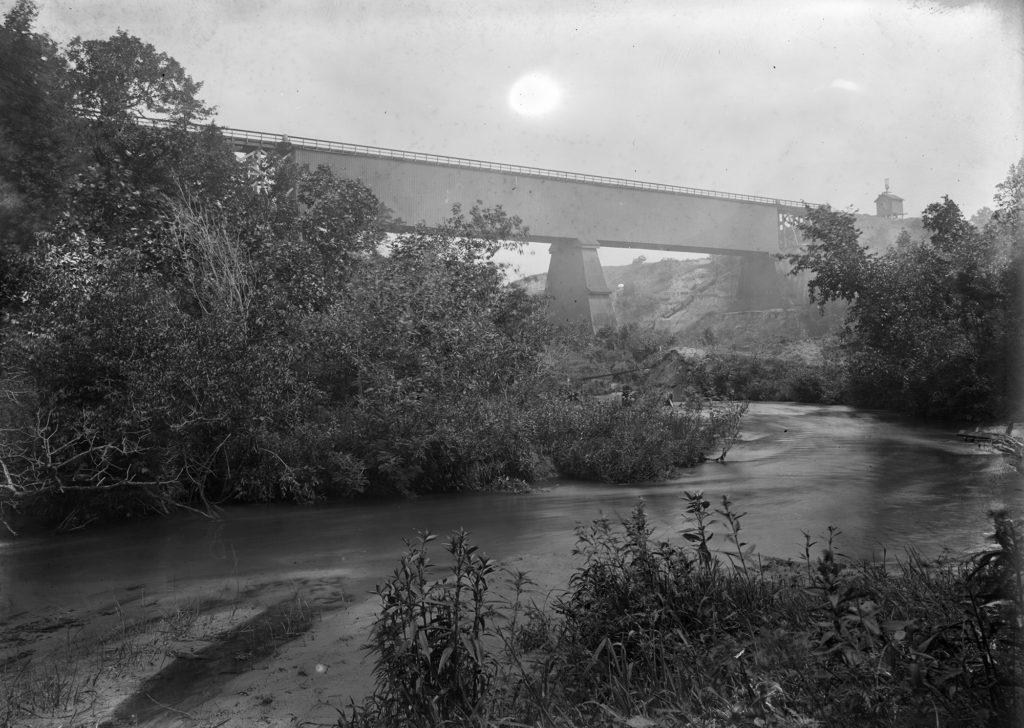 View of the bridge across the Long Pine Creek from the shore. The trusswork is enclosed. July 19, 1900.