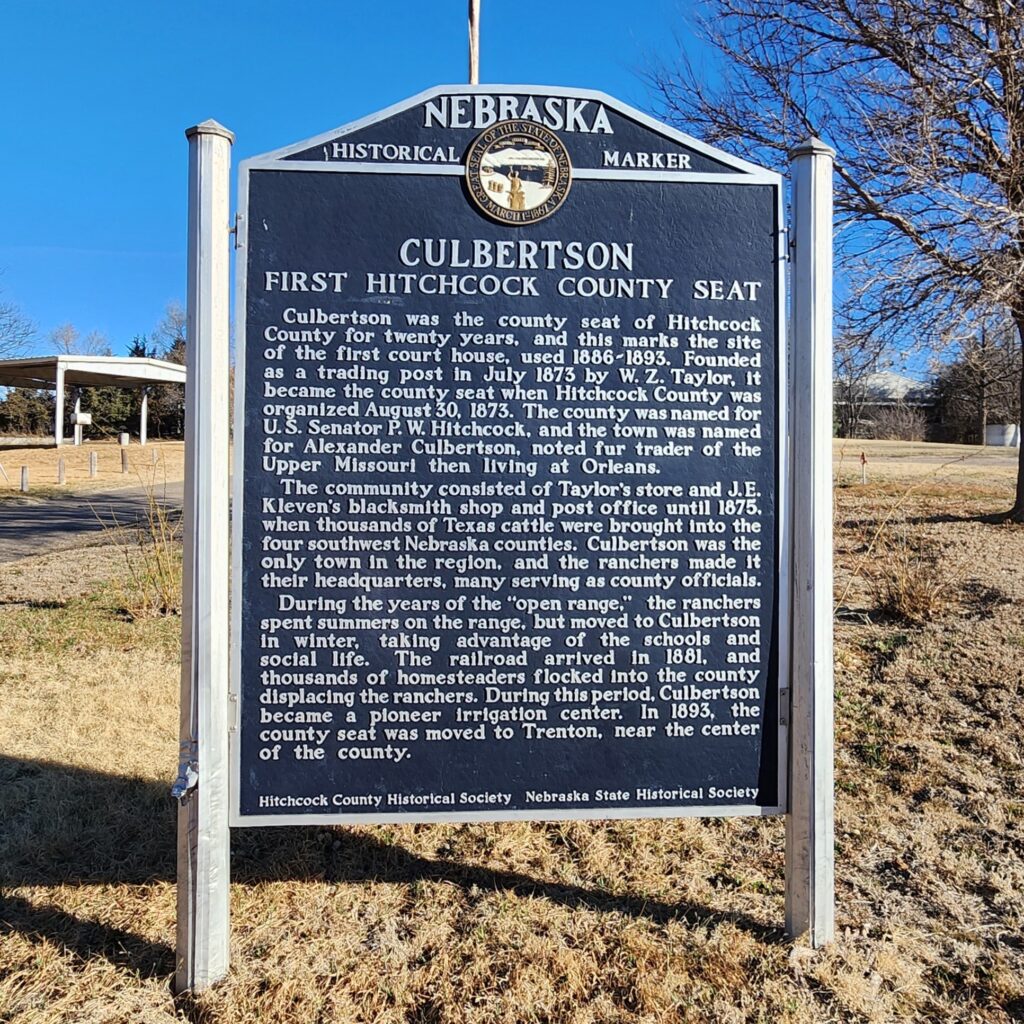 Nebraska historical marker detailing the history of Culbertson, the first seat of Hitchcock County, with text about its founding and development, standing outdoors on a sunny day.