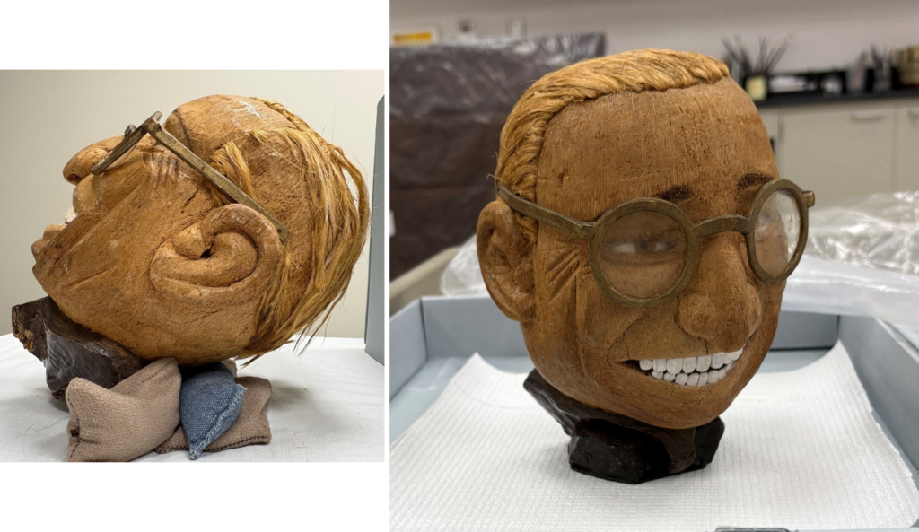 A carved coconut bust resembling Harry Truman with glasses and a wide smile; shown from the side and front, resting on a padded surface in a lab setting.