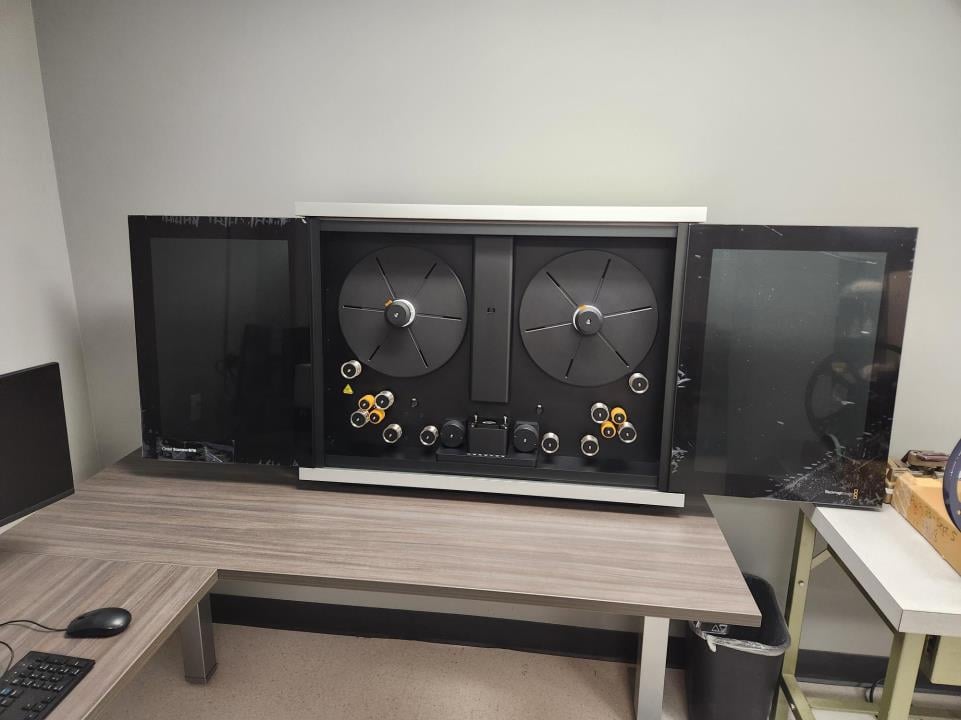 A reel-to-reel film editing machine sitting on an office desk.